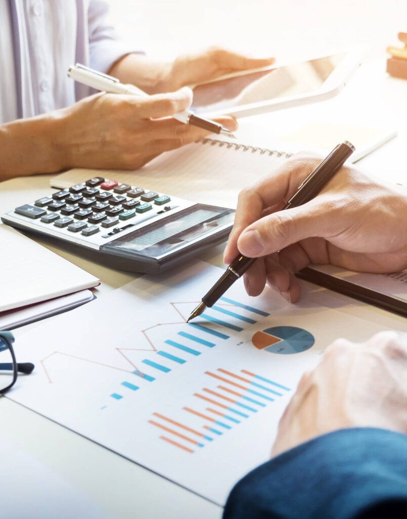 Financial advisor analyzing colorful graphs and charts with a calculator and pen in hand for strategic planning